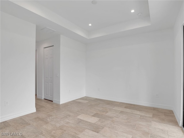 empty room featuring a raised ceiling