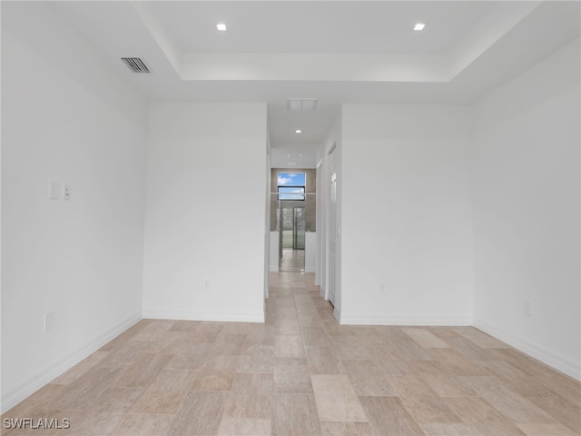 unfurnished room with a tray ceiling