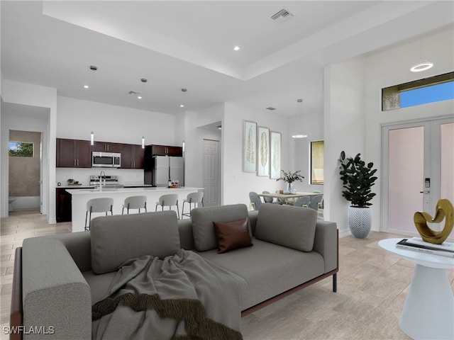 tiled living room featuring a high ceiling and sink