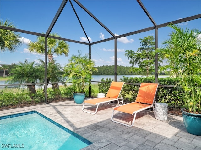 view of pool featuring a lanai, a water view, and a patio area