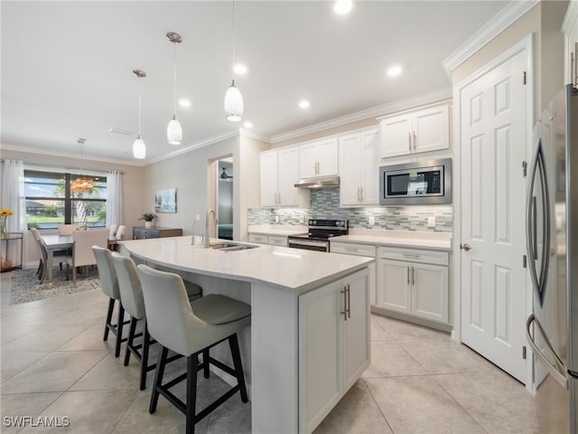 kitchen featuring white cabinets, appliances with stainless steel finishes, hanging light fixtures, and sink