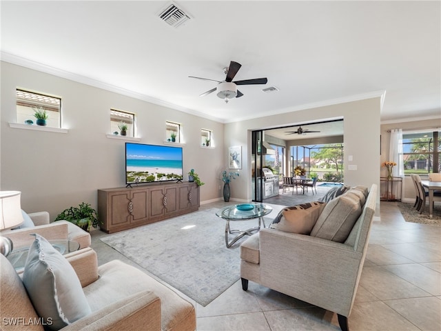 living room with ceiling fan, crown molding, and light tile patterned floors