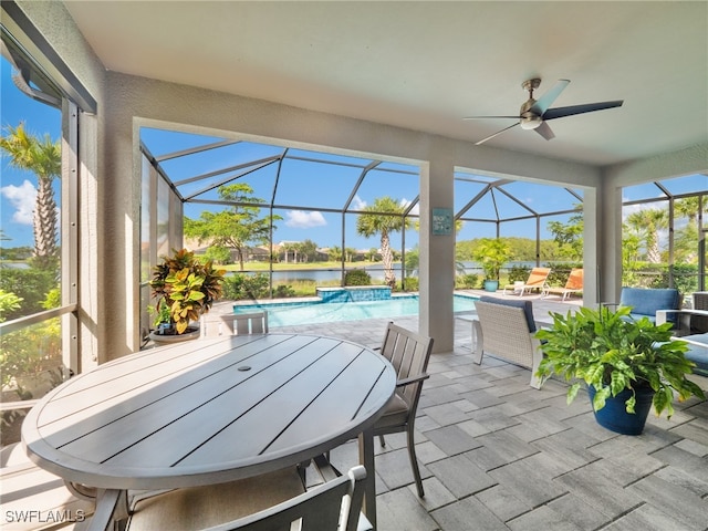 sunroom featuring a water view, a pool, and ceiling fan