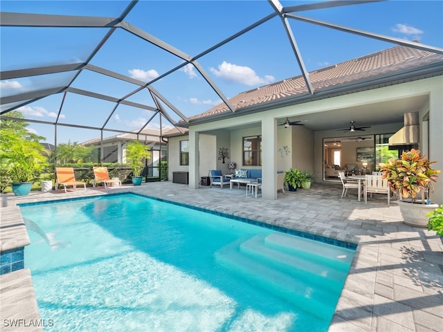 view of swimming pool with ceiling fan, glass enclosure, and a patio