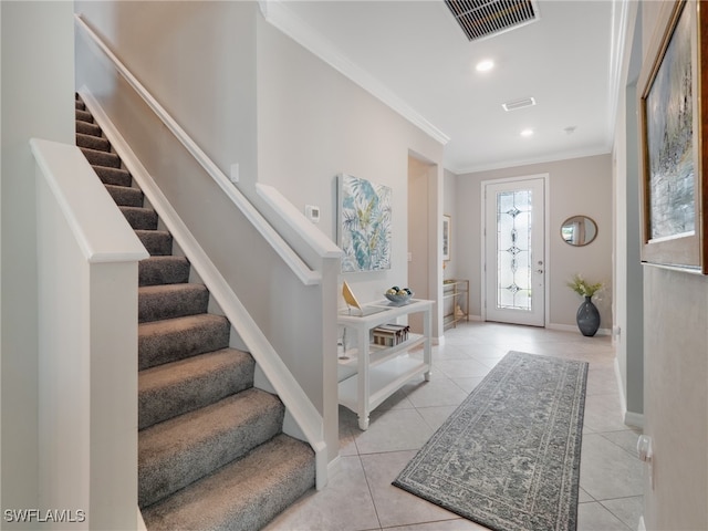 entrance foyer with ornamental molding and light tile patterned flooring