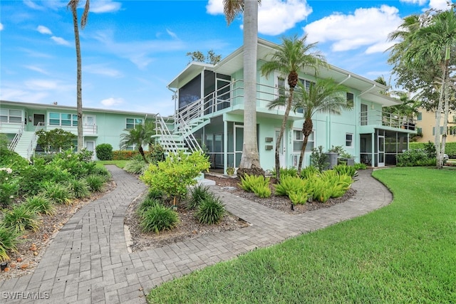 view of home's exterior featuring a sunroom and a yard