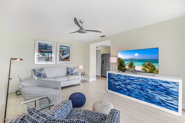 living room with light hardwood / wood-style floors and ceiling fan