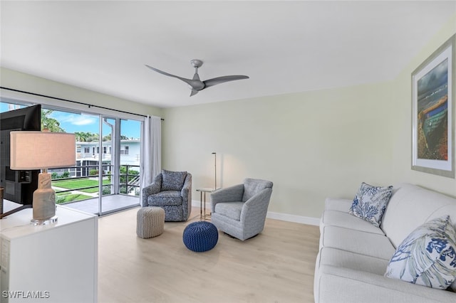 living room with ceiling fan and light hardwood / wood-style flooring