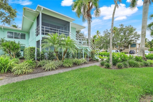 exterior space featuring a sunroom and a lawn