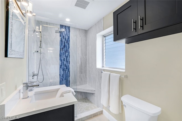 bathroom featuring toilet, vanity, and tiled shower