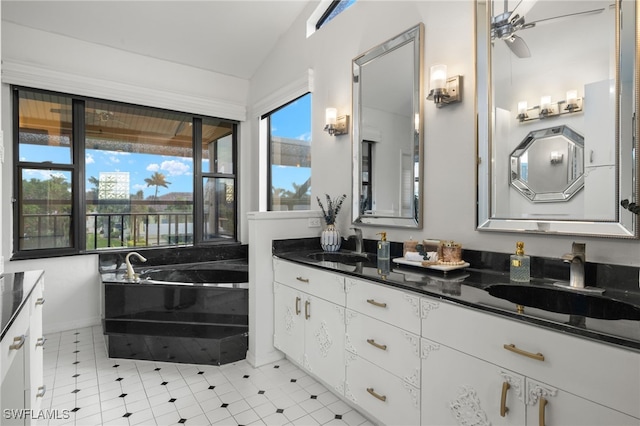 bathroom featuring lofted ceiling, double vanity, a bath, and ceiling fan