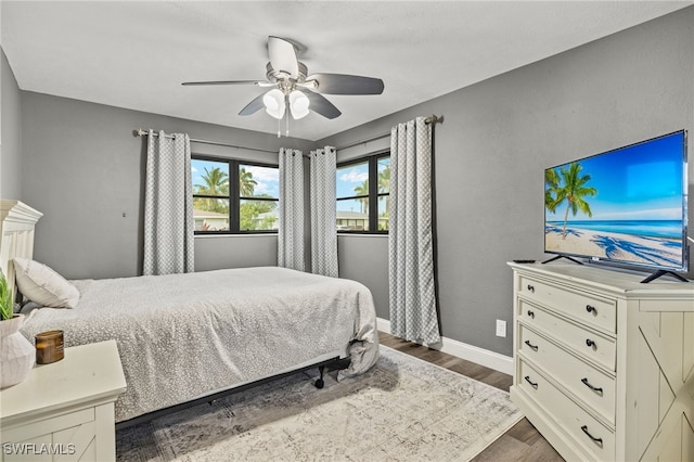 bedroom featuring dark wood-type flooring, baseboards, and ceiling fan