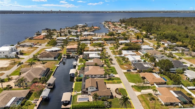 aerial view of property and surrounding area featuring nearby suburban area and a nearby body of water