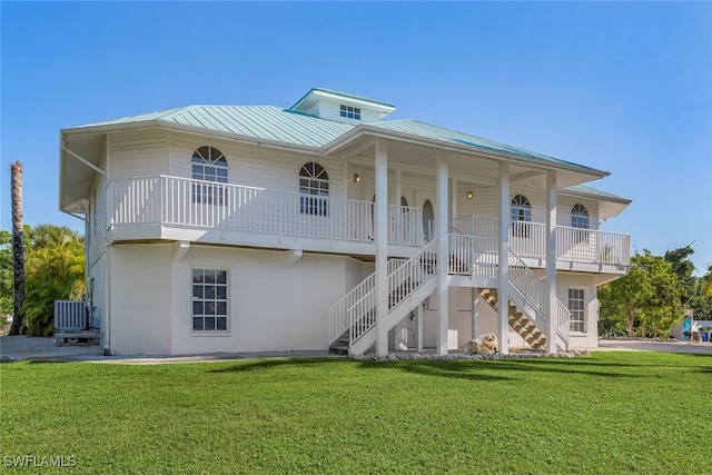 view of front of house with central AC, a front yard, and covered porch