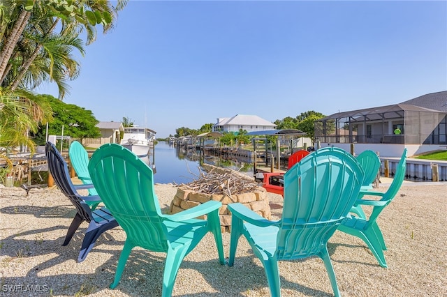 view of patio featuring a water view, a dock, and glass enclosure