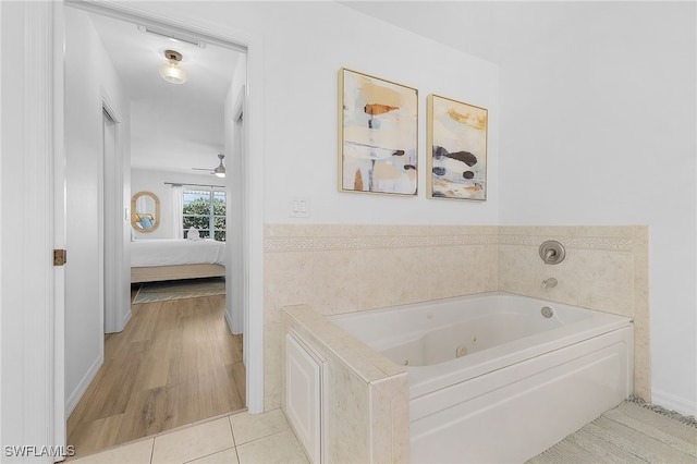 bathroom with ceiling fan, tile patterned floors, and a bathtub