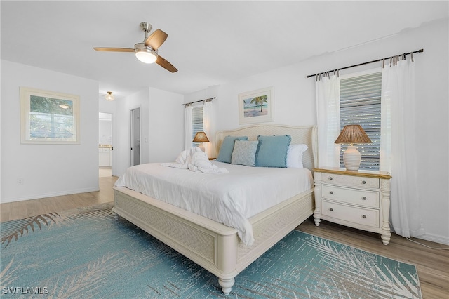 bedroom with connected bathroom, hardwood / wood-style floors, and ceiling fan