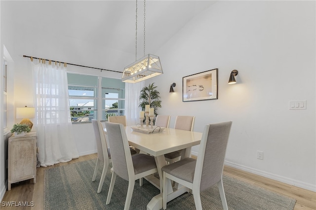 dining space with vaulted ceiling and hardwood / wood-style floors