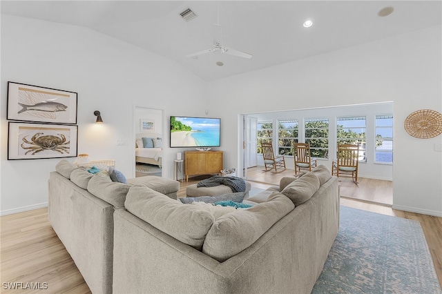 living room featuring high vaulted ceiling, ceiling fan, and light wood-type flooring