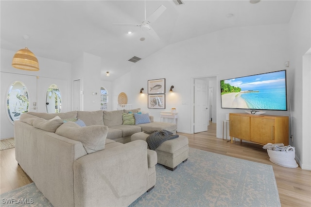 living room featuring high vaulted ceiling, ceiling fan, and light wood-type flooring