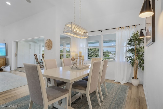 dining room featuring a high ceiling and light wood-type flooring