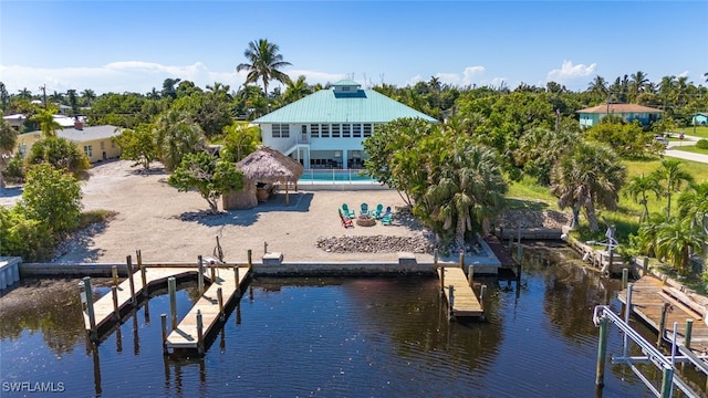 view of dock with a water view, a pool, a gazebo, and a patio area