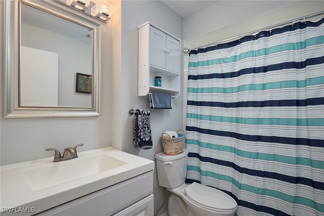 bathroom with vanity, toilet, and walk in shower