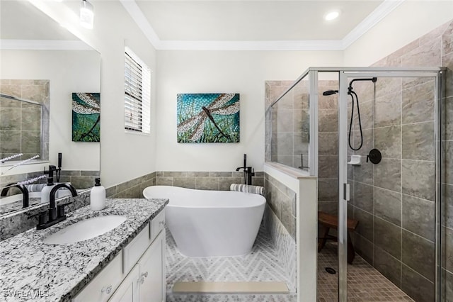 bathroom with vanity, separate shower and tub, ornamental molding, and tile walls