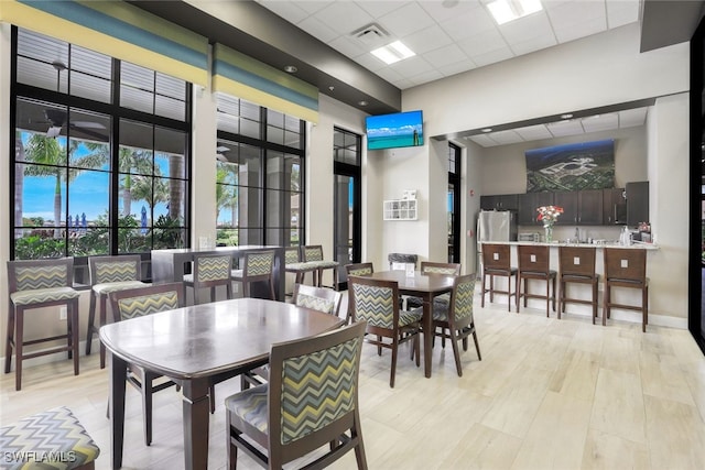 dining room featuring light hardwood / wood-style flooring and a drop ceiling