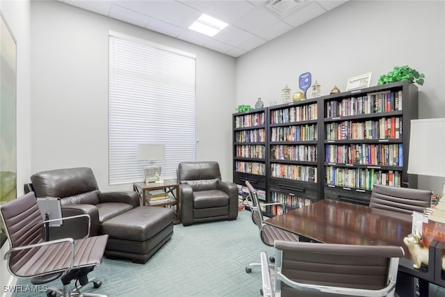 office space featuring a paneled ceiling and light carpet