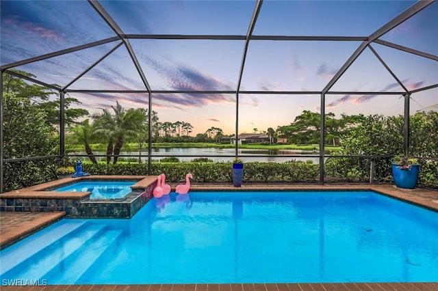 pool at dusk with an in ground hot tub, a water view, and a lanai