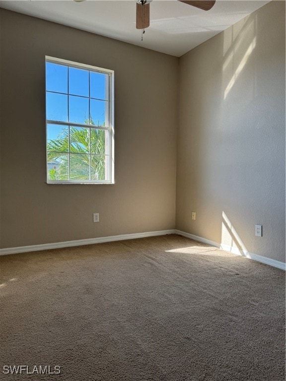 carpeted spare room featuring ceiling fan