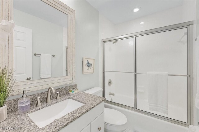 full bathroom featuring shower / bath combination with glass door, vanity, and toilet