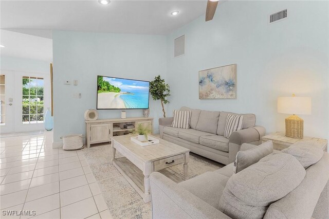 living room featuring vaulted ceiling, ceiling fan, and light tile patterned floors