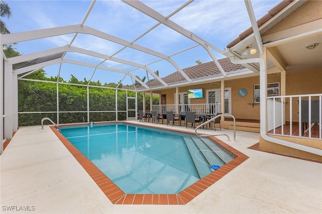 view of swimming pool featuring glass enclosure and a patio area