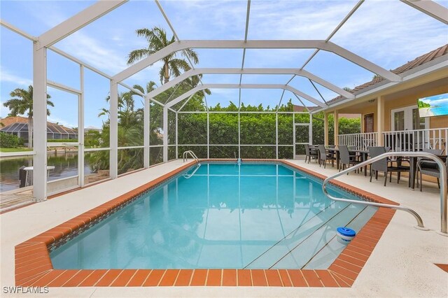 view of swimming pool featuring a patio, a water view, and a lanai