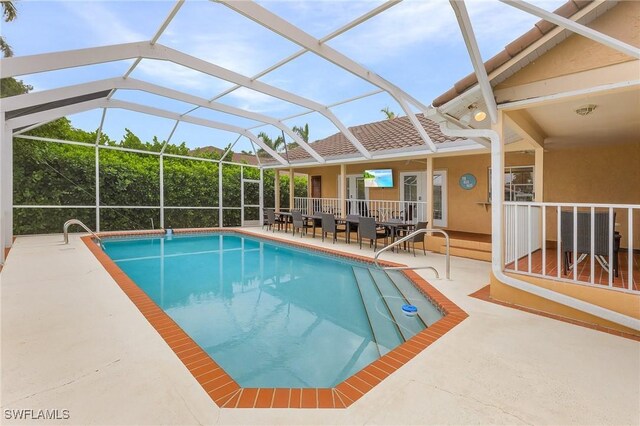 view of swimming pool featuring glass enclosure and a patio area