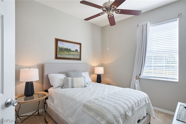 bedroom with ceiling fan, light carpet, and multiple windows