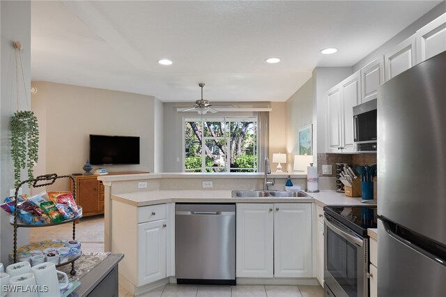 kitchen with appliances with stainless steel finishes, sink, and white cabinetry