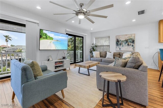 living room with ceiling fan and light wood-type flooring