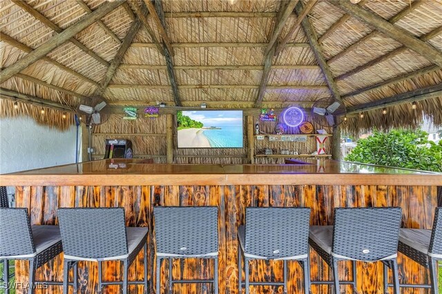 bar featuring lofted ceiling with beams