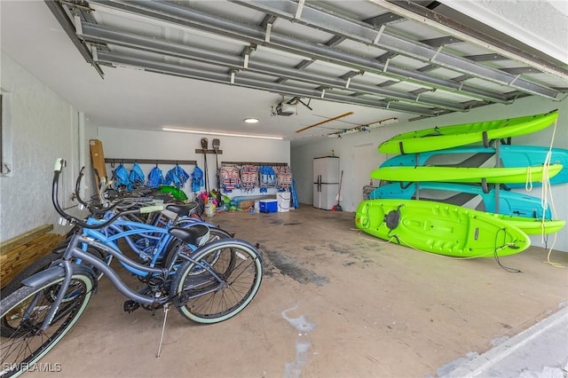 garage with a garage door opener and white refrigerator