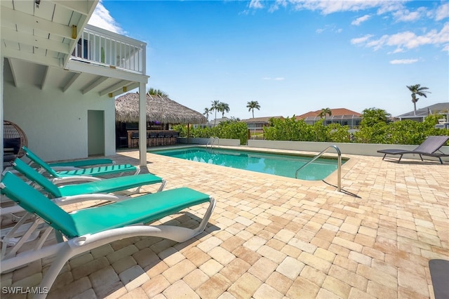 view of pool with a bar and a patio
