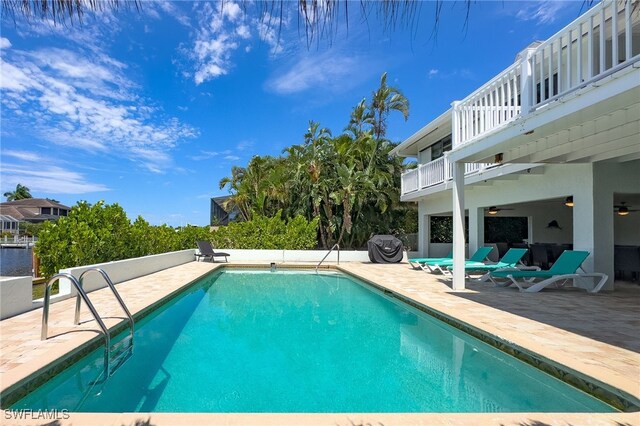 view of swimming pool with ceiling fan and a patio area