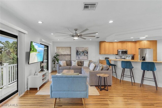 living room featuring light wood-type flooring and ceiling fan