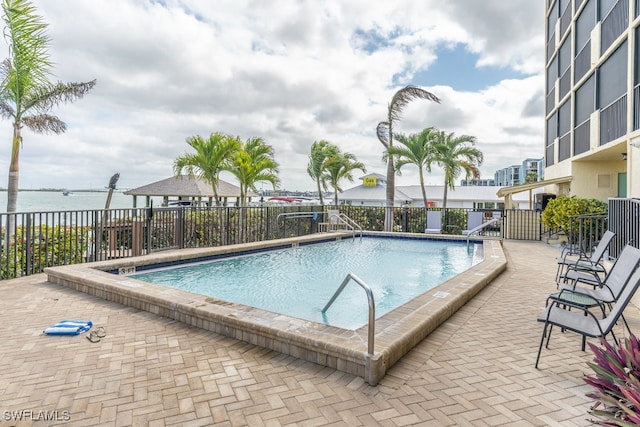 view of pool featuring a patio and a water view