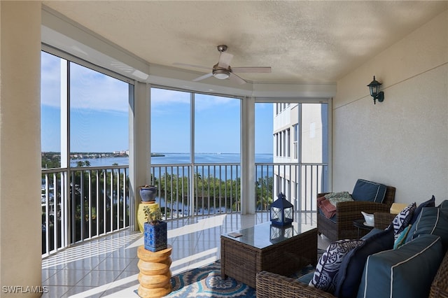 sunroom featuring a water view and ceiling fan