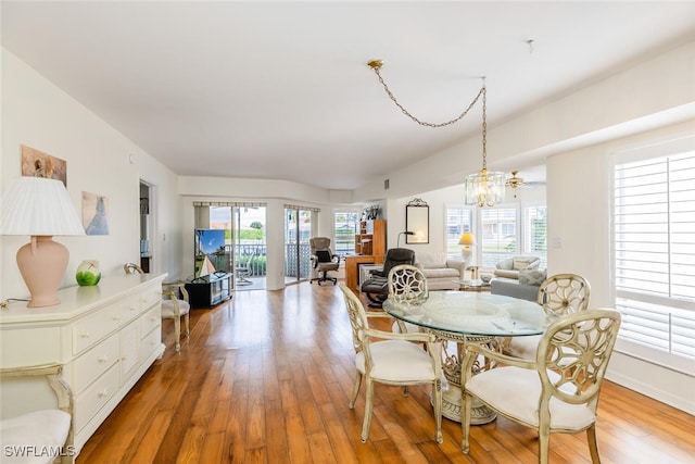 dining room with plenty of natural light, an inviting chandelier, and hardwood / wood-style flooring