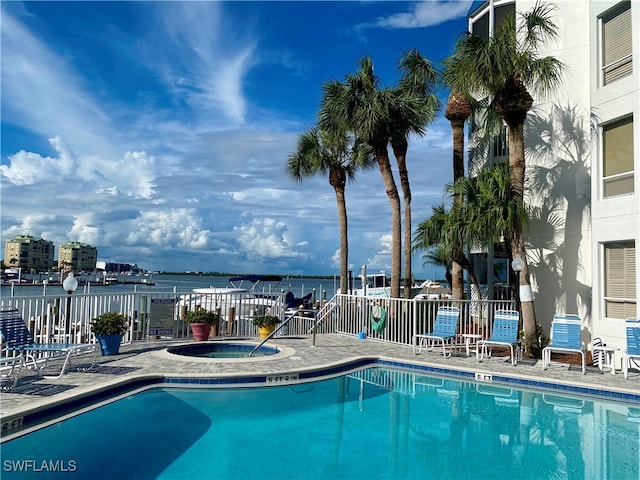 view of swimming pool featuring a water view and a community hot tub