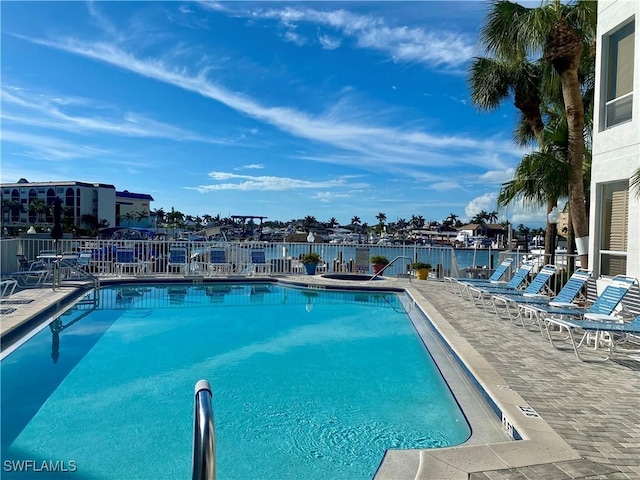 view of swimming pool featuring a patio area and a water view